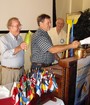 Mark Werum, 2010/11 Woodland Rotary Club President, is 'swept in', to the accompanyment of broomsticks, corn husks, and pennies jingling in the cup.  Bob Griffith and Frank Gardner are the escorts.
